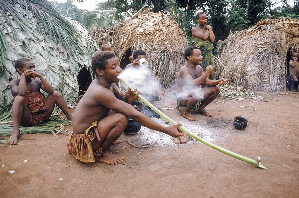 Pygmee smokes marijuana from a clay bowl through a stem of a palm. They trade meat from their hunt for the herb grown by agrarian tribes.