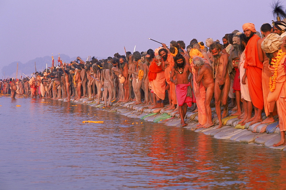 Having arrived at the confluence of the Yamuna and Ganges river for a purifying bath, these sadhus wait for their guru to enter the waters first. Kumbh mela festival: Allahabad India