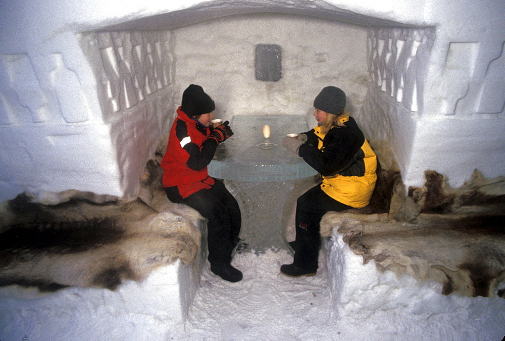 Local girls drink hot chocolate inside the bar area at Ice Hotel, Jukkasjarvi, Sweden.