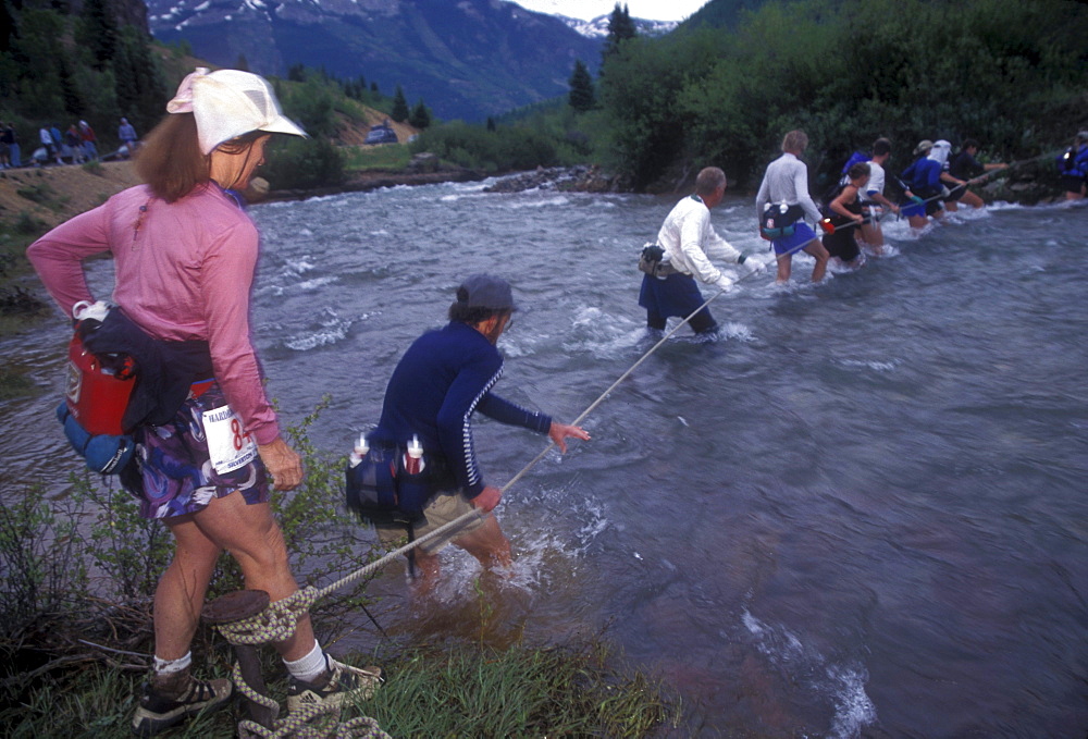 Runners cross a river in the hardrock 100. Billed as the toughest running race in America by many, the Hardrock 100 covers 100 miles and includes climbing a total of nearly 30,000 feet (equivilent to climbing Everest). The race begins and ends in Silverton, Colorado and climbs several 13,000 foot passes and one 14,000 foot summit.