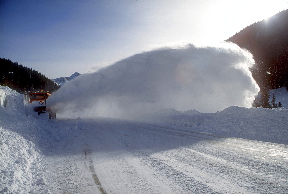 At an avalanche area near Silverton, Colorado in the San Juan Mountains a plow clears snow from the road after an avalanche was safely set off while the road is closed. This stretch of highway receives more avalanches than any other in North America.