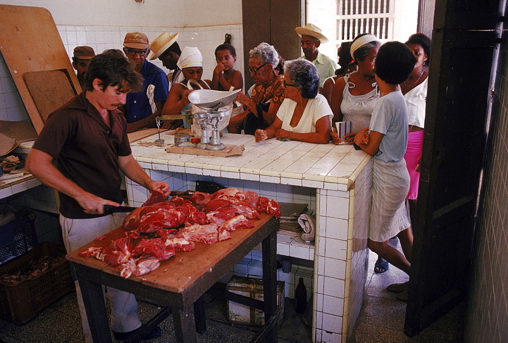 Inside butcher shop people await their turn to get a ration of meat. Trinidad, Cuba.