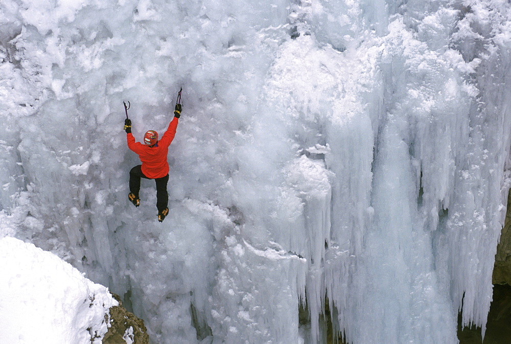 An ice climber ascends a frozen waterfall in Ouray, Colorado.