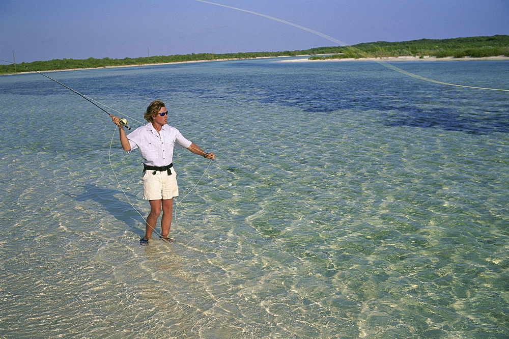 A fly-fisherman casts to a bonefish on Crooked Island in the Bahamas.