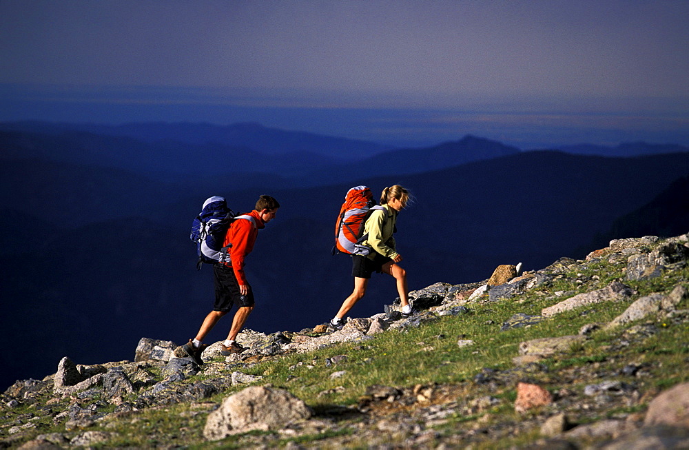 Tommy Caldwell and Beth Rodden hike up hill on a ridge off of Longs Peak in Rocky Mountain National Park, Colorado.