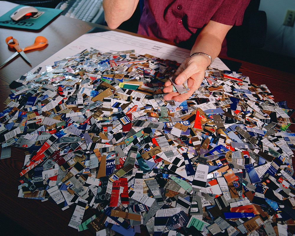 Credit card debt counselor Mary Rammel with a pile of credit cards cut up by debtors upon entering a credit counseling program in Willmington, DE, the credit card capital of the world. There are over 1.3 billion credit cards in America and in 2003 they accounted for over 786 billion dollars in credit card debt.