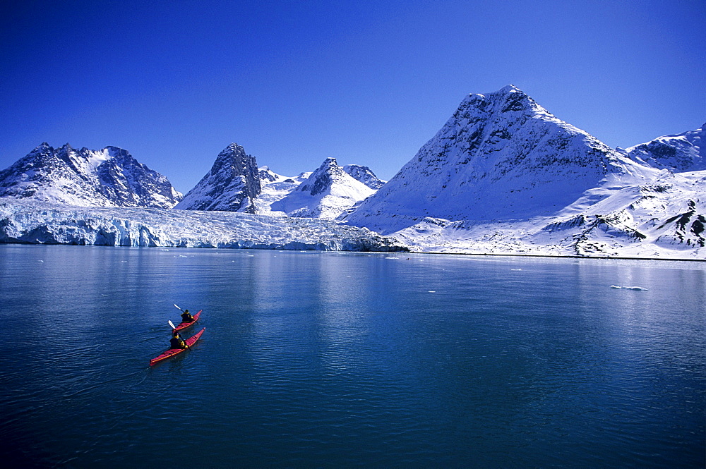 A female sea kayaker exploring the glaciers of the Evigshead Fjord, Greenland.