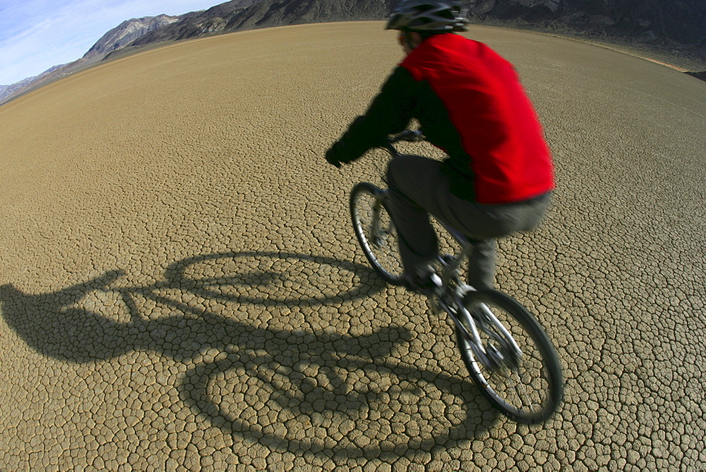 DEATH VALLEY, CA, JANUARY 07: A  mountain biker on The Racetrack, a dried lake bed in Death Valley National Park, California on January 07, 2006.