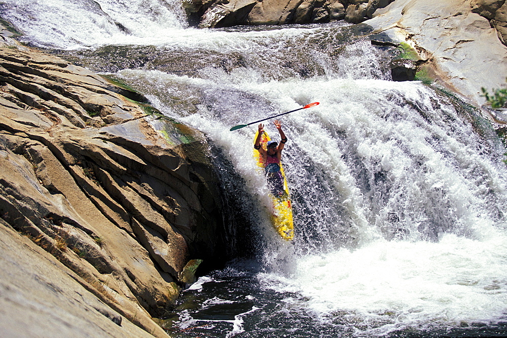 Bill Russell drops a waterfall with his hands over his head in a kayak on Brush Creek. Kernville, California.