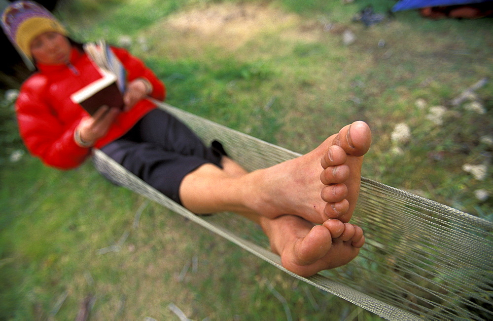 Pauline Hsieh relaxes with a book in a hammock in her camp outside of El Chalten in Patagonia, Argentina.