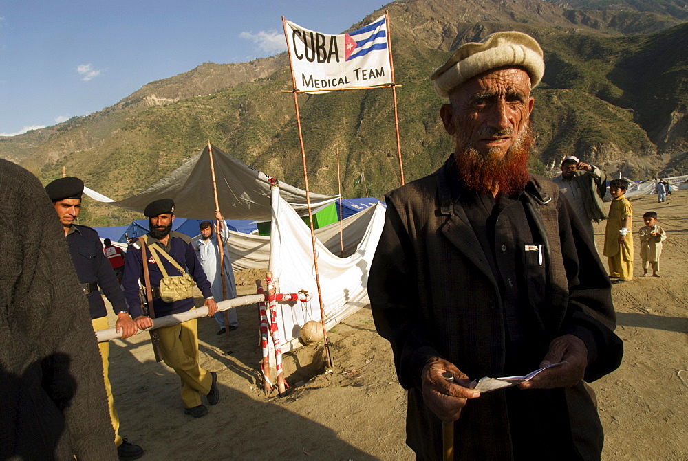 A Pashtun man stands outside the Cuban hospital in the Meira camp for earthquake survivors, NWFP, Pakistan.  The Cuban government sent 30,000 doctors, nurses and other personnel to set up field hospitals throughout the earthquake affected area.  The Meira Tent camp (also called Mera, or Maria camp), is run by the Pakistani army like a small city, and  is located on the Indus River in the Battagram district.  The camp, the largest for displaced people in Pakistan, hosts over 21,000 earthquake survivors, primarily Pashtuns from the Allai valley in Pakistan's NWFP, one of the areas worst-hit by the October 8, 2005 earthquake.