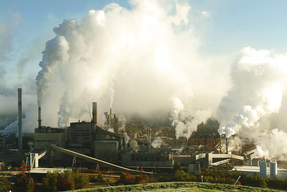 Steam rises from the stacks of International Paper's Androscoggin Mill in Jay, Maine.