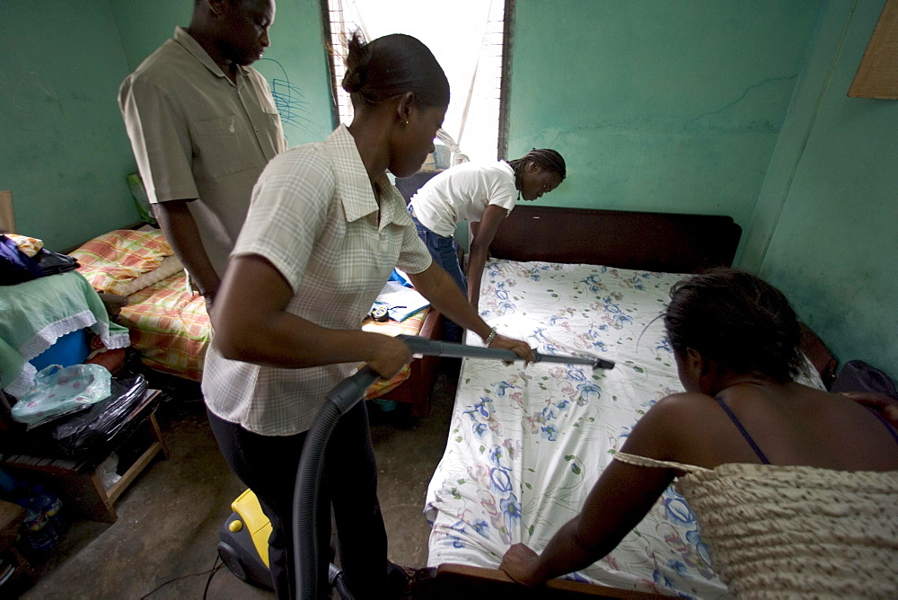 Research assistants and technicians from the University of Ghana collect dust samples from the living rooms and bedrooms of  children in Accra, Ghana.  The samples will be analyzed for the presence of dust mites, fungus', and animal allergens to help researchers better understand why children in wealthier homes have higher rates of allergies and asthma than poorer children.  The leading theory is that higher rates of helminth (parasite) infections among poorer children are affecting the immune system in a way that offers protection from allergies and asthma.  The study aims to find out what the worms are doing, isolate the beneficial effect and replicate it.