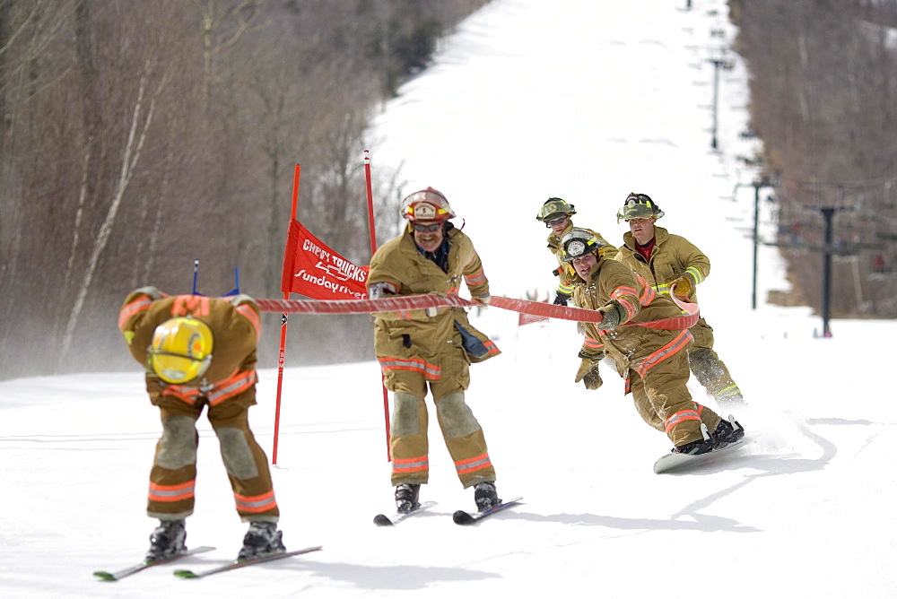 A group of fireman are in the annual fireman hose race at Sunday River ski resort in Bethel, Maine.