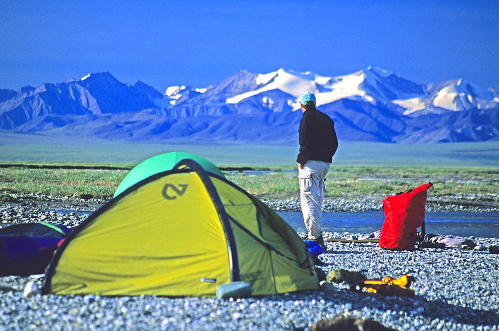 A camper on the coastal plain, 1002 Area, of the Arctic National Wildlife Refuge looks back towards the mountains, Alaska.