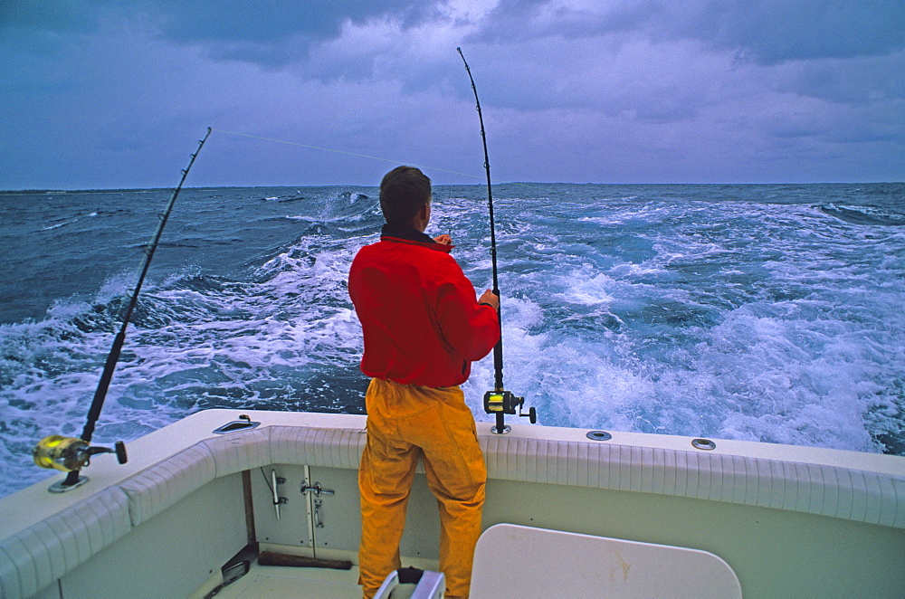 A fisherman rigs trolling lines for big game fish in the Pacific Ocean off Midway Atoll, Hawaii.