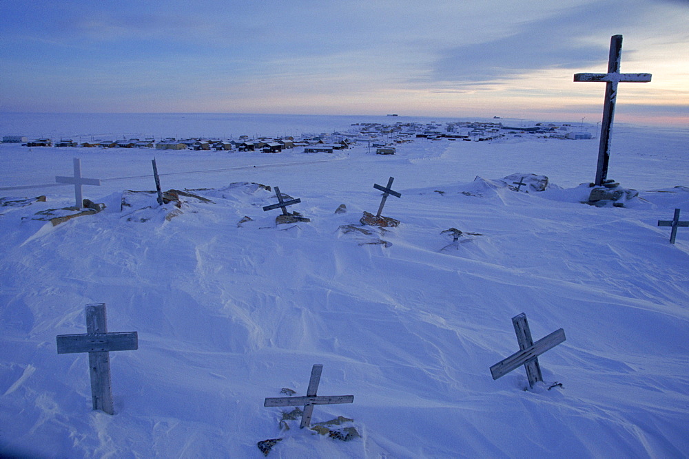 The cold sunlight of early March brushes grave markers above Igloolik, one of Nunavut's 28 isolated towns. Winter night lasts seven weeks, and July heat averages just 43¬∞ F.