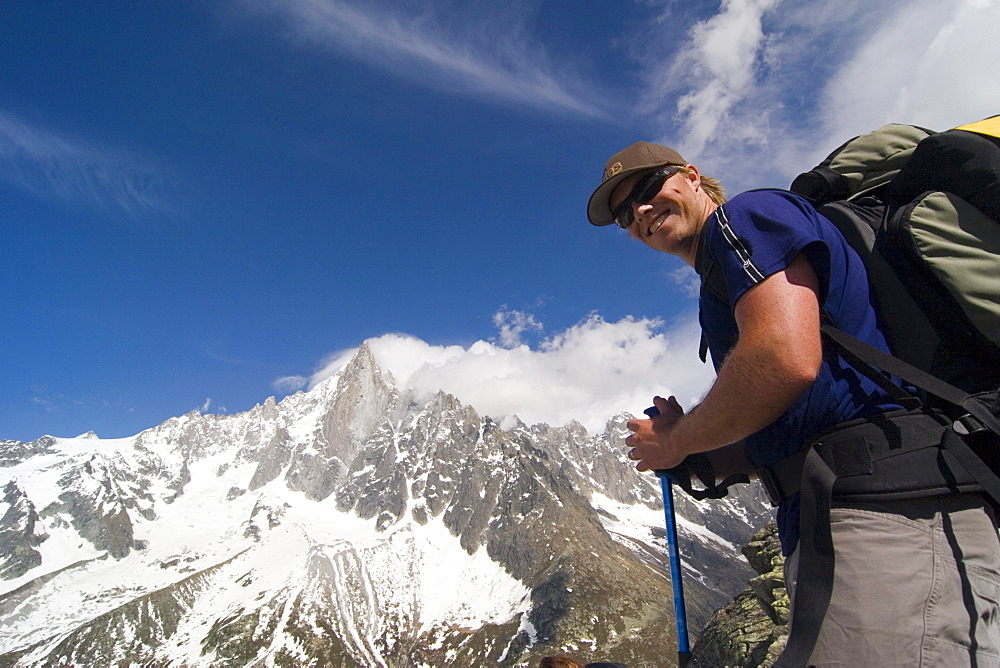 A hiker smiles in front of a mountain in the French alps near Chamonix.