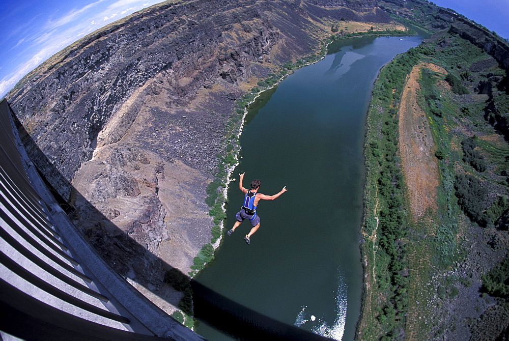 A BASE jumper jumps off of a bridge in Twin Falls, Idaho (Wide Angle Lens).