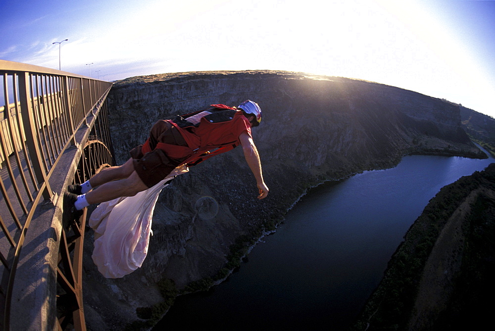 A BASE jumper jumps off of a bridge in Twin Falls, Idaho (Wide Angle Lens).