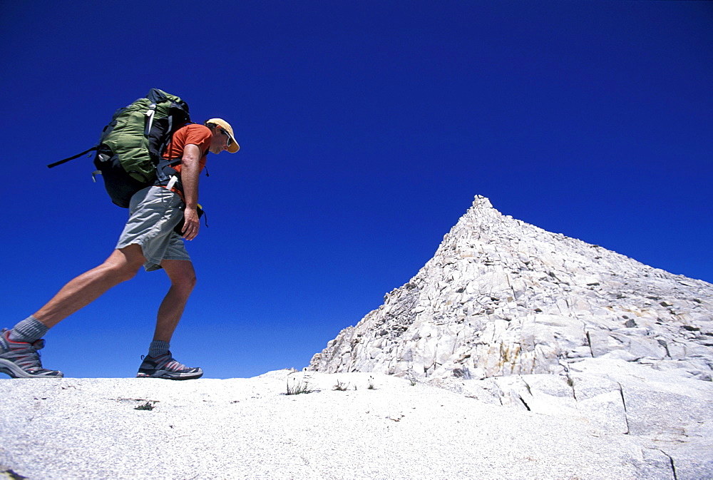 Feet with trail running shoes hiking by in Eastern Sierra Nevada mountains, California.