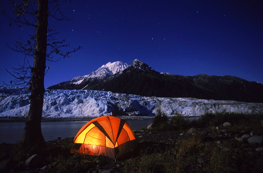 A camper's tent glows near the face of Child's Glacier in the Copper River Delta area of Alaska.