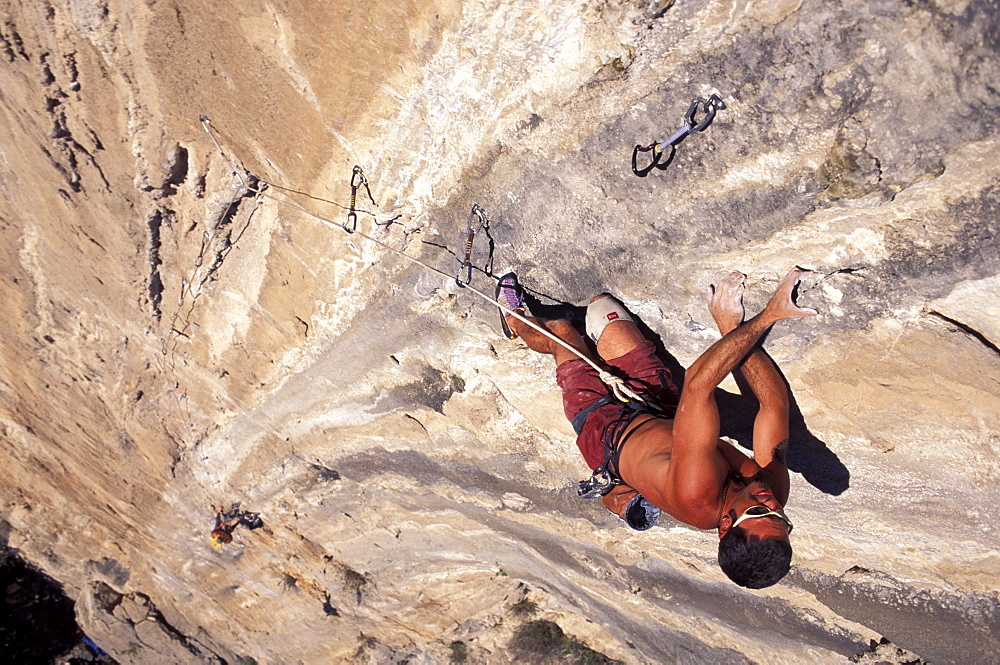 A man climbing a big wall with another man below him in El Potrero Chico, Mexico (High Angle Perspective).