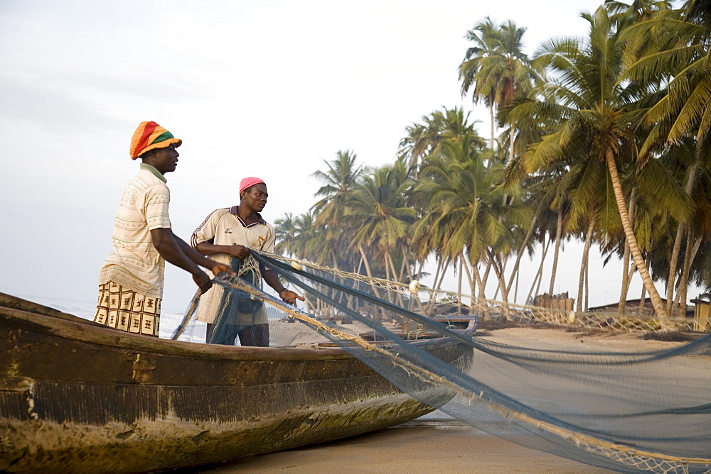 Fishermen pulling nets on a beach in Ghana