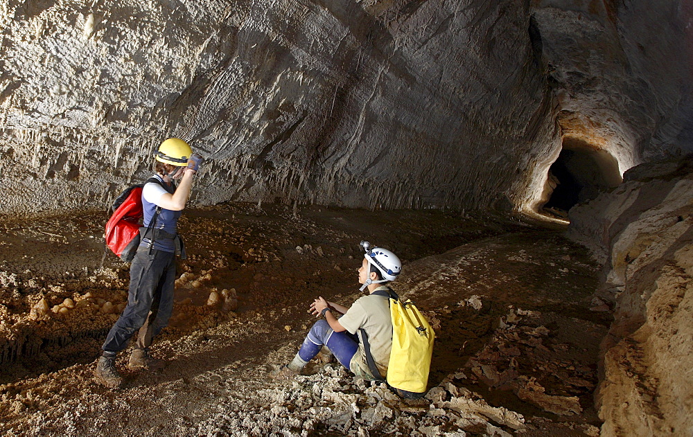 Two female cave explorers stop for a rest whilst exploring this delightfully linear tunnel deep in Whiterock (cave).