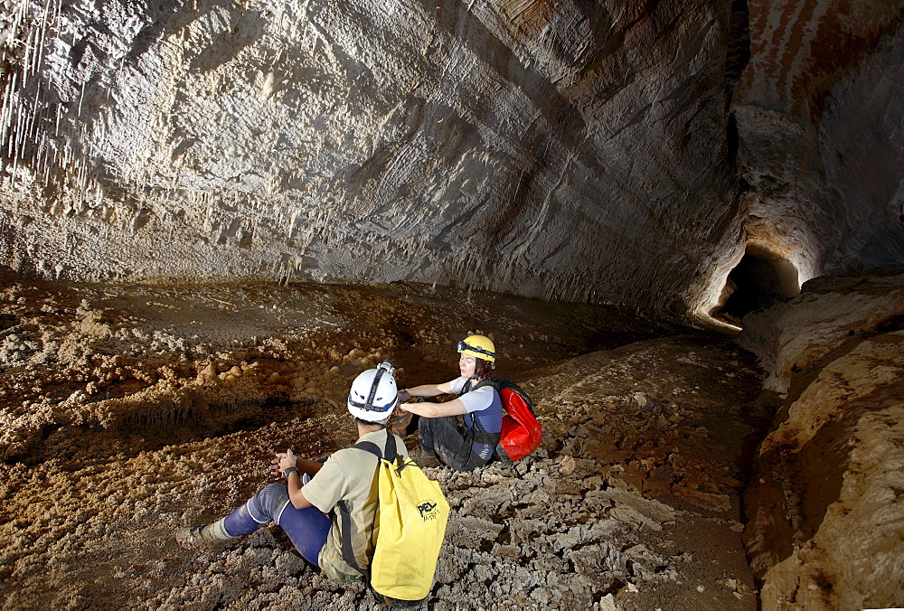 Two female cave explorers stop for a rest whilst exploring this delightfully linear tunnel deep in Whiterock (cave).