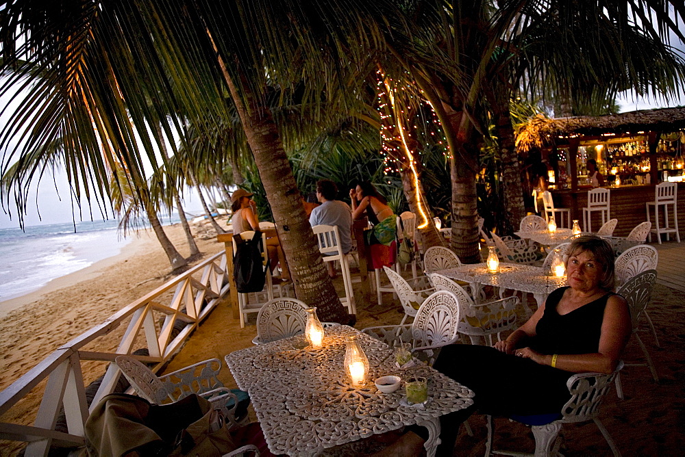 A woman has a drink at a beach bar in the Dominican Republic