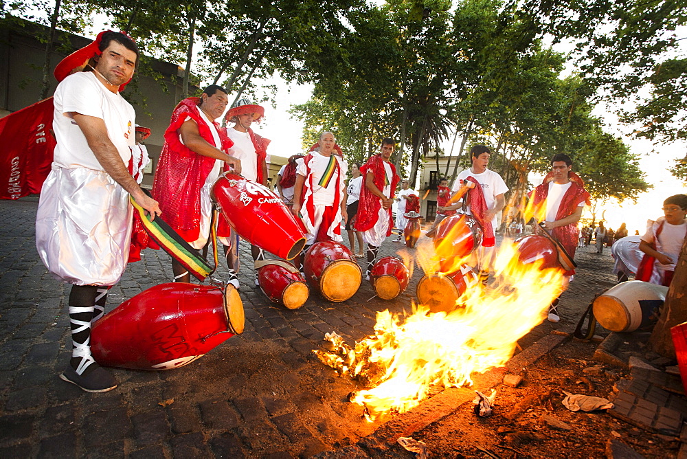 A group of men heating the drums before playing at the "desfile de llamadas" during the carnival celebrations in Colonia del Sacramento, Uruguay.