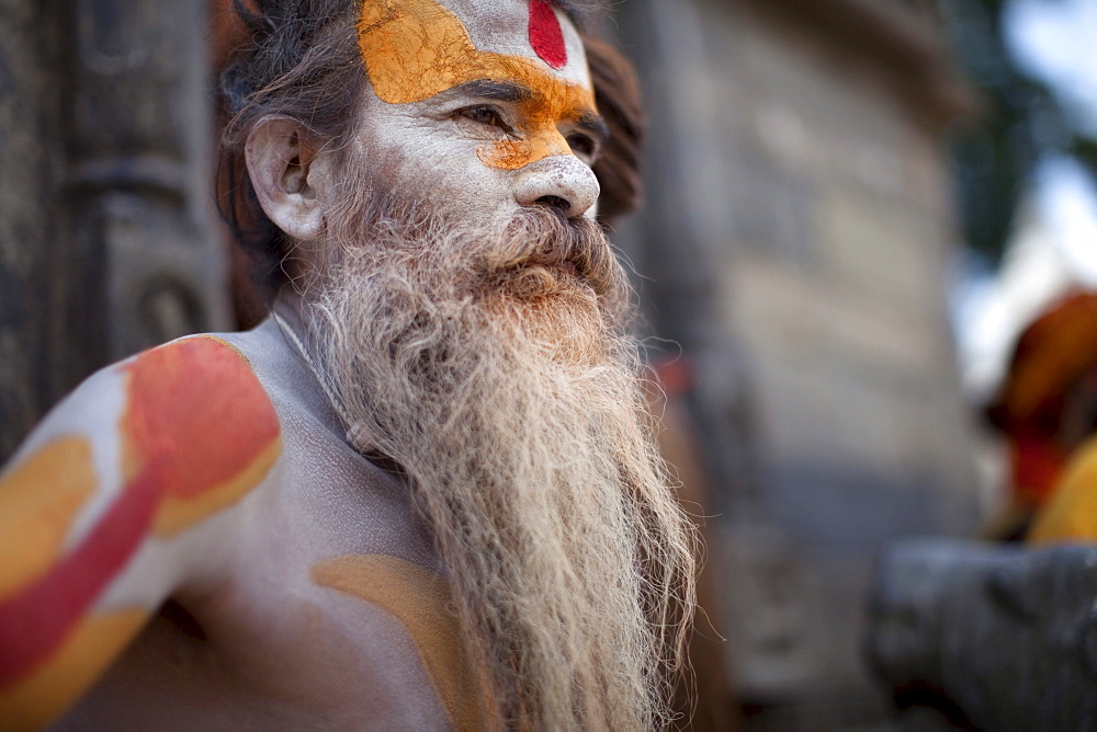 A Hindu priest, a sadhu and esthetic, with body paint poses in a Kathmandu, Nepal temple.