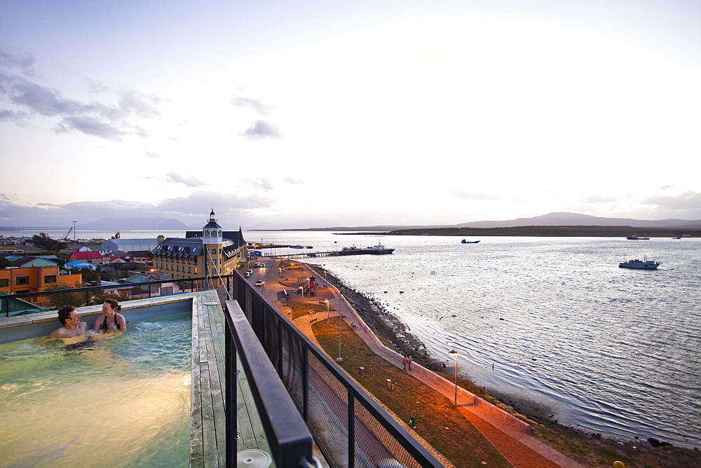 PUERTO NATALES, PATAGONIA, CHILE. A couple sits in an empty hot tub overlooking the waters surrounding Puerto Natales.