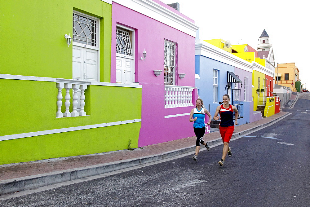 Katrin Schneider and Susann Scheller running trough the streets of the very colorful Bo-Kaap or Capa Malay Quarter of Cape Town. South Africa.