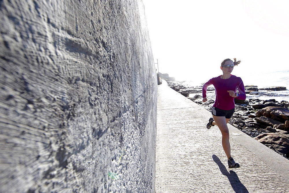 Katrin Schneider running between St.James and Muizenberg on the shores of False Bay. Cape Town, South Africa.