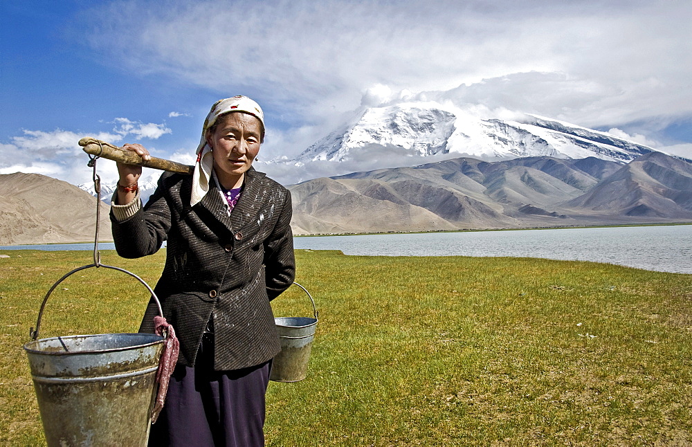 Local woman carrying water, Karakul lake, Karakoram Highway, Xinjiang Province, China