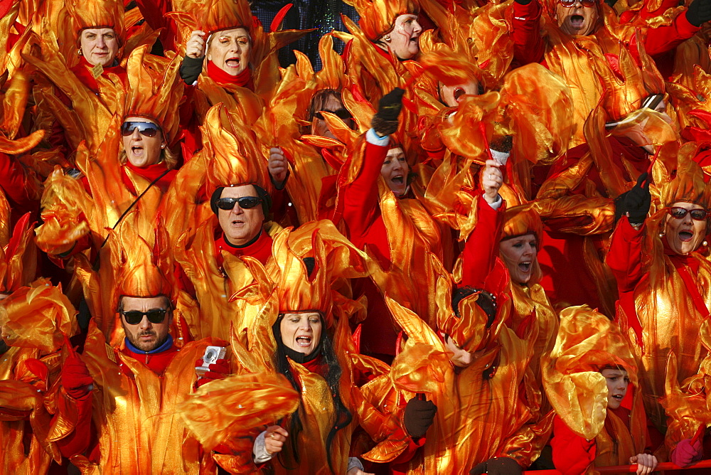 Masks and caricatures of politicians singing and dancing in the streets and enormous paper mache floats, surrounded by thousands of people, in the great celebration of the Carnival of Viareggio.