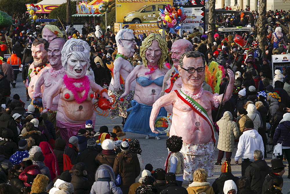 Masks and caricatures of politicians singing and dancing in the streets and enormous paper mache floats, surrounded by thousands of people, in the great celebration of the Carnival of Viareggio.