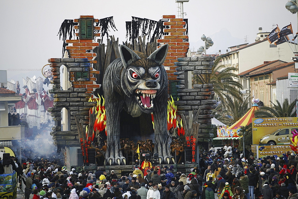 Masks and caricatures of politicians singing and dancing in the streets and enormous paper machee floats, surrounded by thousands of people, in the great celebration of the Carnival of Viareggio.