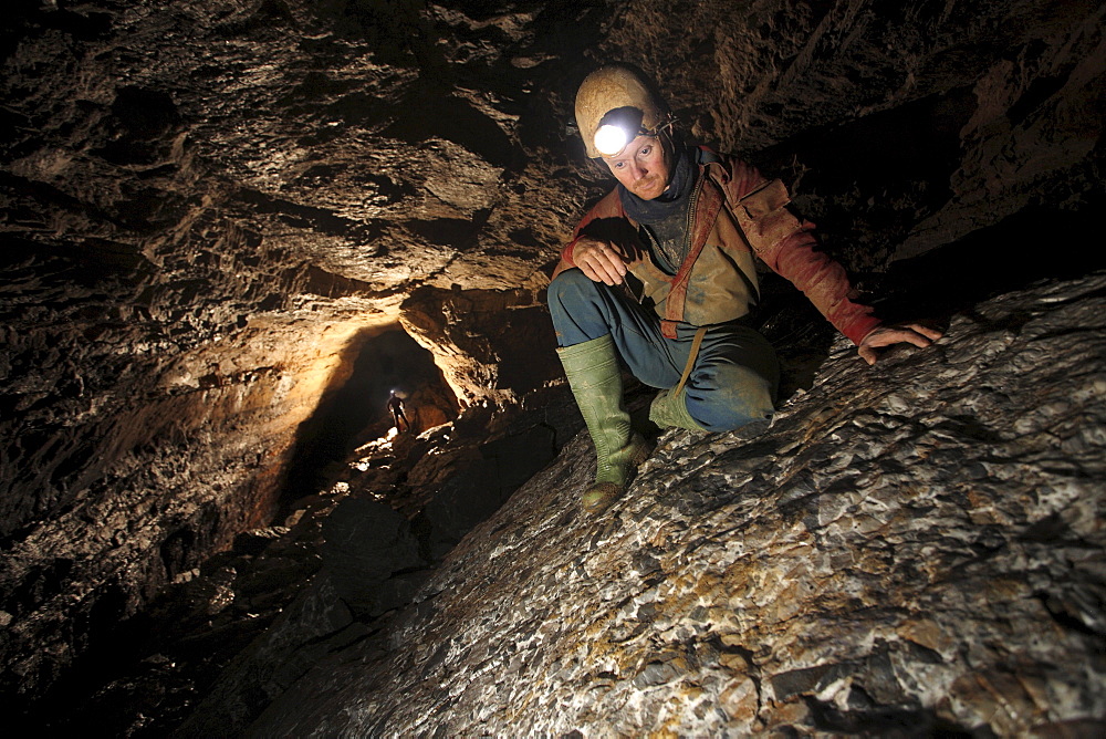 A man admires rock patterns underground in a cave in China.