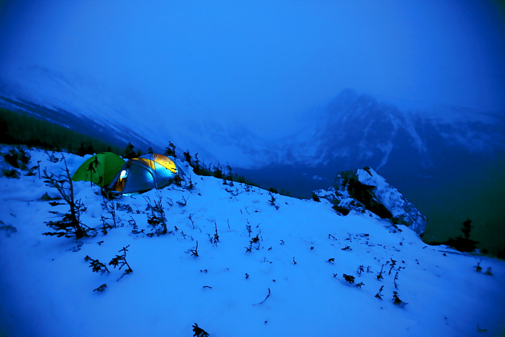 Two tents sit in the snow, side by side, as night falls on Mt. Washnigton.