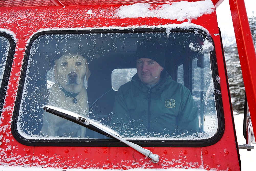 Lead Snow Ranger with his avalanche rescue dog in a snow cat.