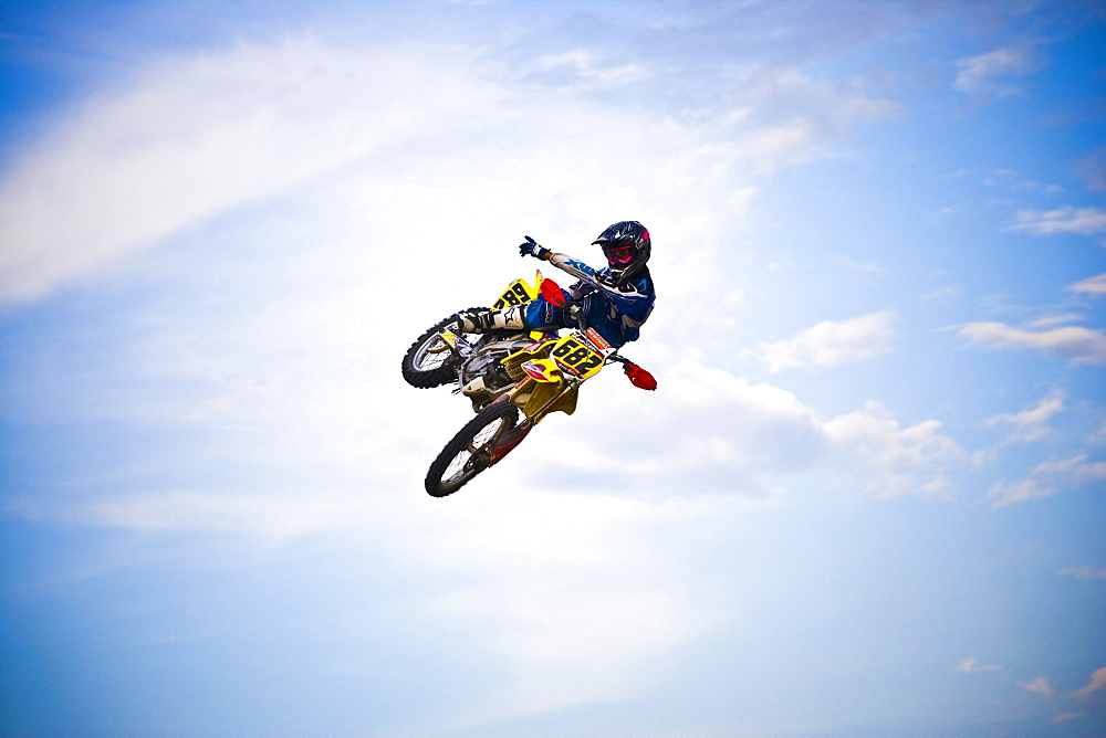 A motocross biker points towards the sky as he flies through a jump in Brainerd, Minnesota.