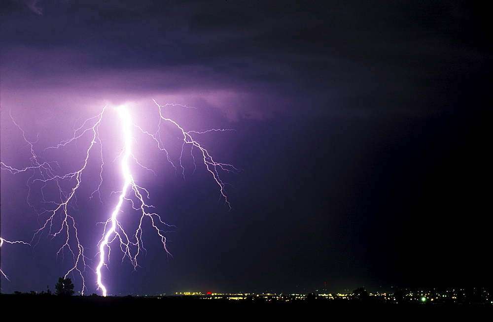 A large lighting bolt lights up the sky as it strikes near Fort Collins Colorado.