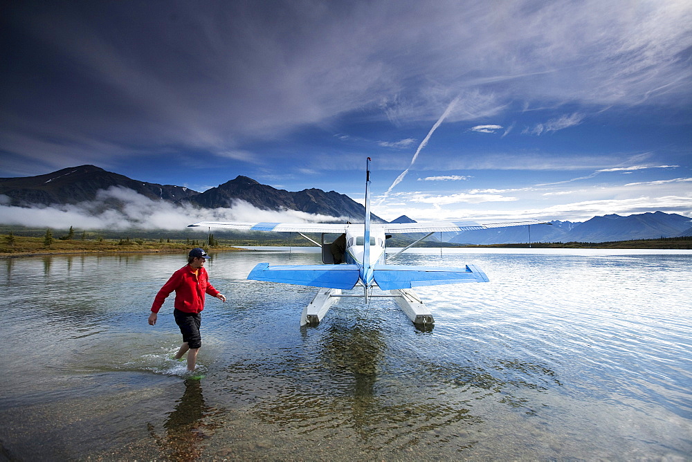 A man walks around a float plane in Alaska.