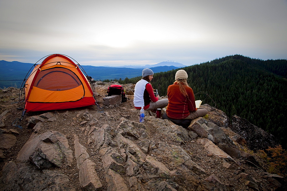 Two young women enjoy the view while camping along Sleeping Beauty in the Pacific Northwest