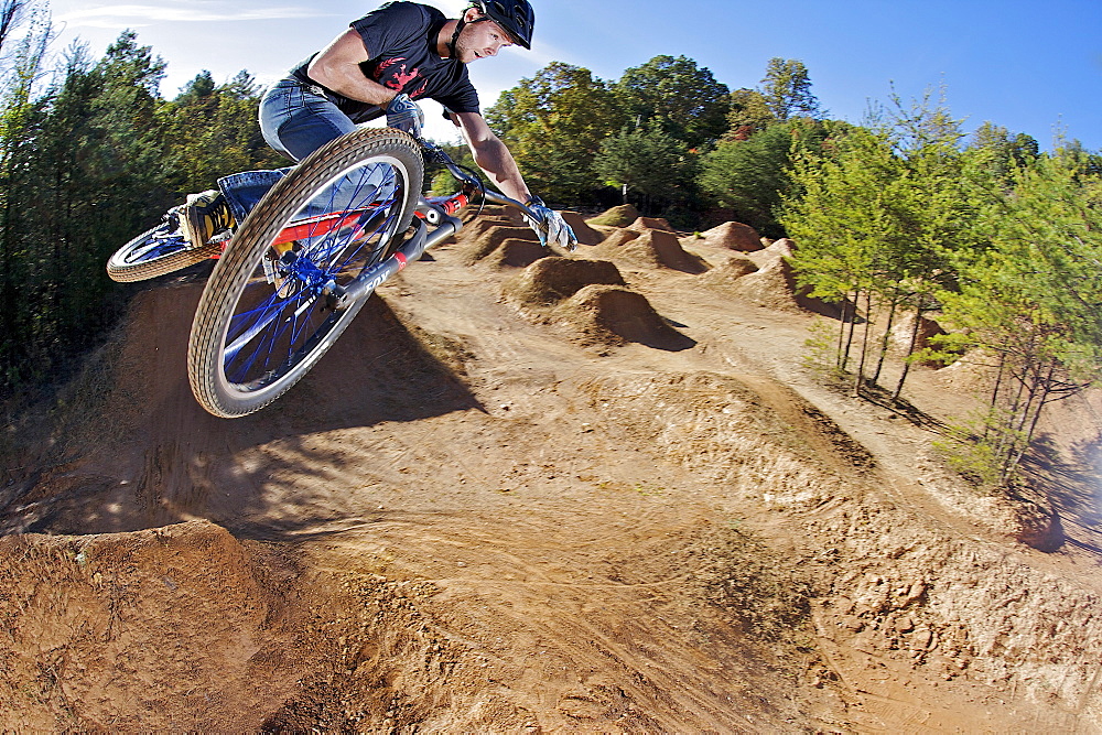 A man flying through the air on a mountain bike.