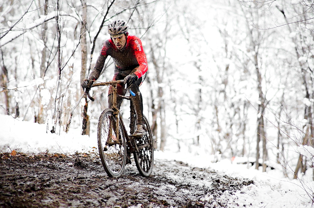 A cyclists races in the mud and snow at a Cyclocross race in Boulder, CO.