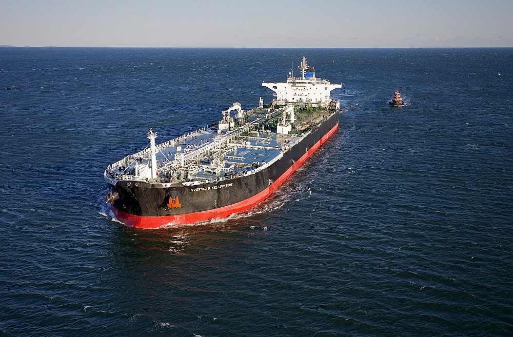 Oil tanker being piloted by tug boats into Portland Harbor, Maine.